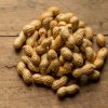 In-shell groundnuts heaped on a wooden table
